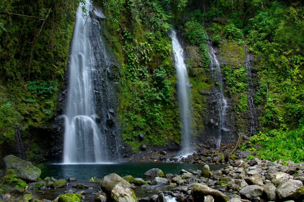 Materuni Waterfalls Tour A lush waterfall cascading into a serene pool in the forests of Cartago, Costa Rica.