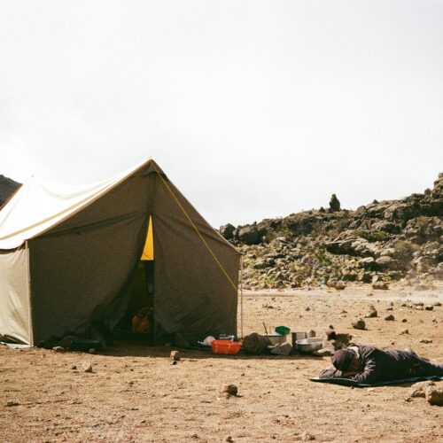 Tent setup amidst rocky terrain at Mount Kilimanjaro, Tanzania. Perfect for adventurers.