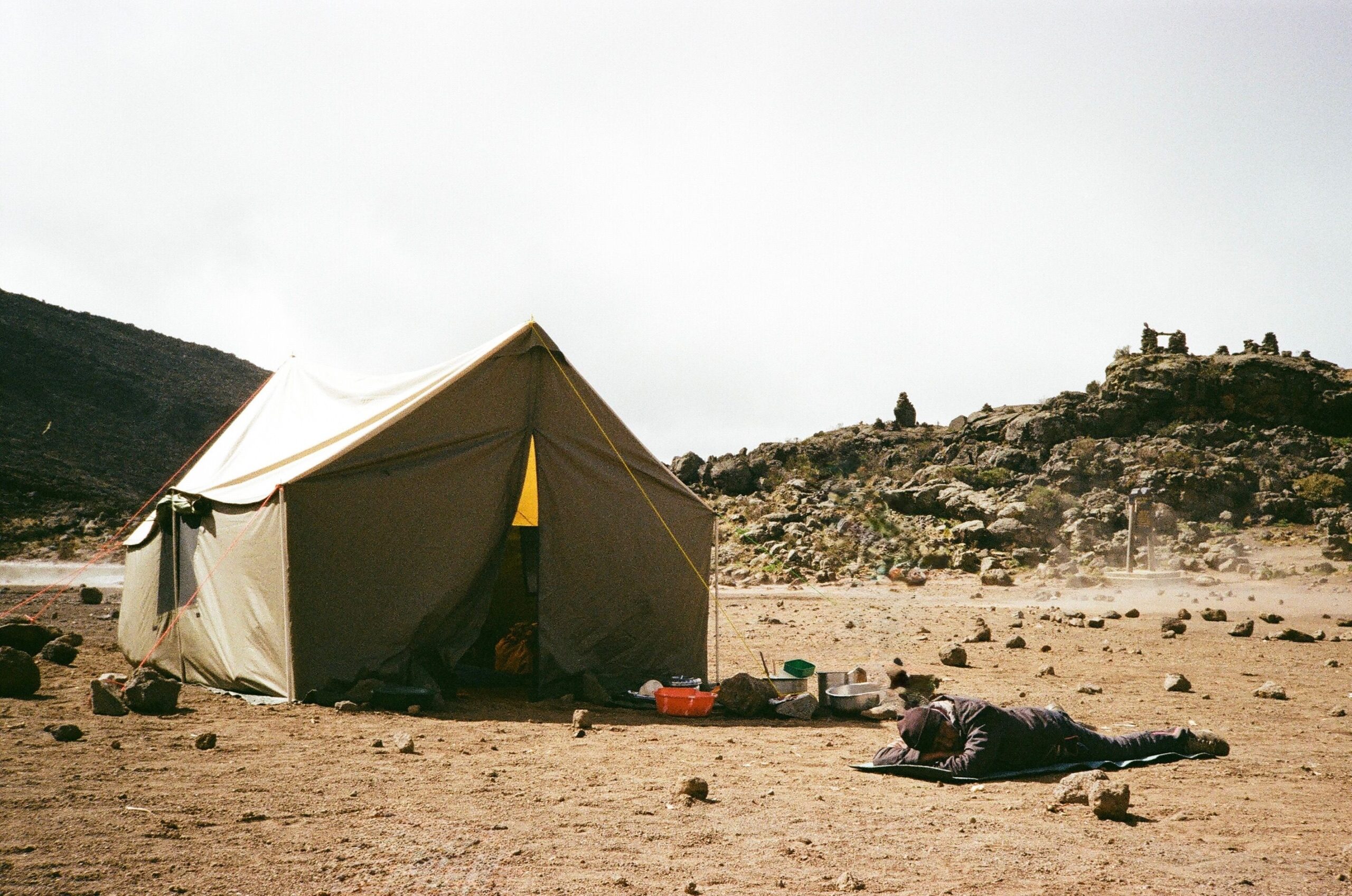 Tent setup amidst rocky terrain at Mount Kilimanjaro, Tanzania. Perfect for adventurers.
