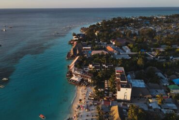 Travel Blogs Stunning aerial photograph of Nungwi Beach, Zanzibar capturing the serene coastline at sunset.